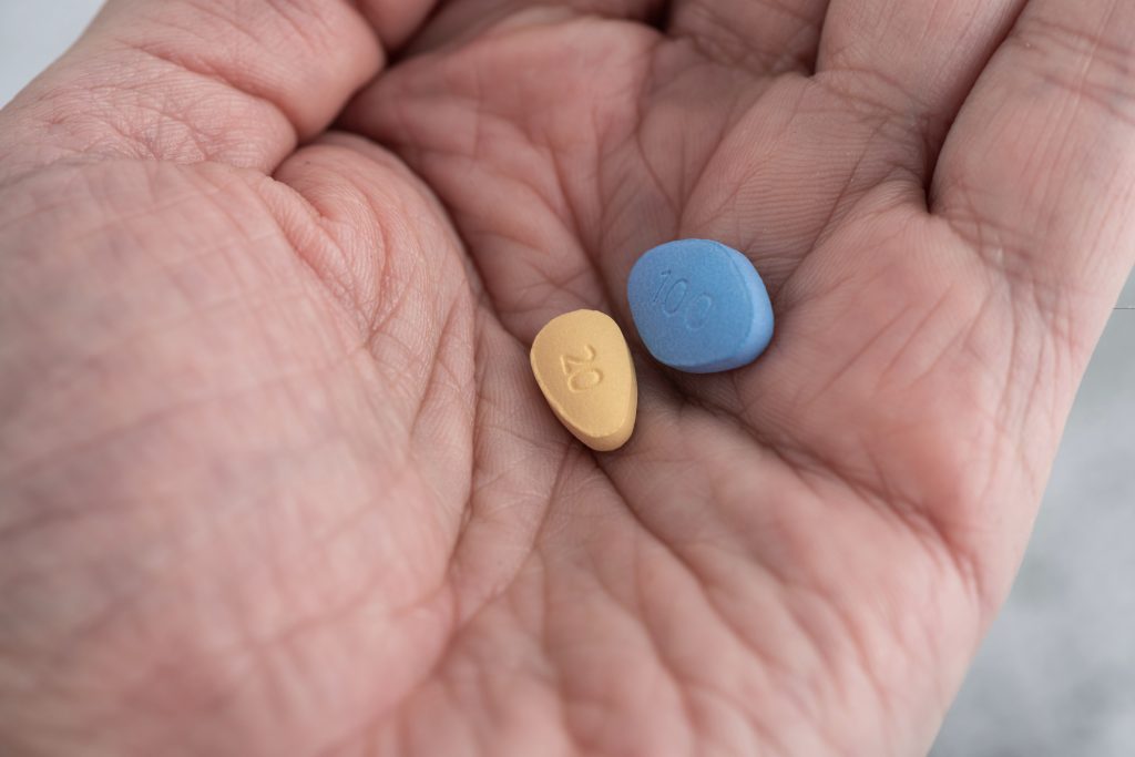 Cialis and Viagra pills in a hand comparing onset, duration, and lifestyle fit for men with ED