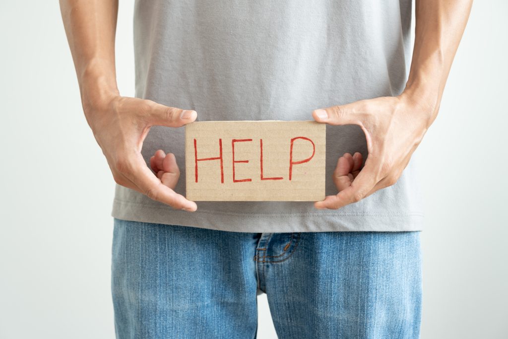 Man holding help sign at waist representing discreet, science-backed men's prescription wellness.